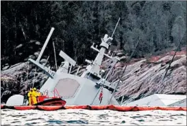  ?? MARIT HOMMEDAL/NTB SCANPIX ?? The Norwegian frigate KNM Helge Instad is partly submerged Tuesday after capsizing off the coast near Bergan where it collided with a tanker Thursday night.