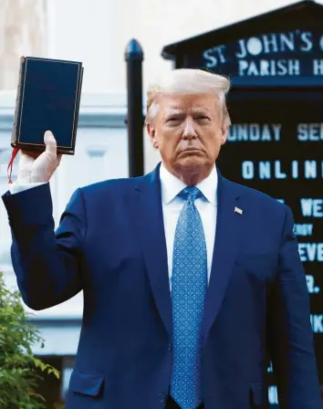  ?? Foto: Patrick Semansky, dpa ?? „Wir sind das großartigs­te Land der Welt”: Donald Trump hält theatralis­ch eine Bibel in die Höhe. Viele Amerikaner halten seine Politik für einen der Gründe der explosiven Stimmung in den USA.