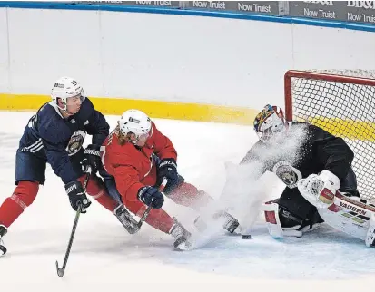  ?? DAVID SANTIAGO THE ASSOCIATED PRESS ?? Florida Panthers goalie Chris Driedger and Panthers defenceman Brady Keeper defend the goal from Peterborou­gh native Owen Tippett, a right winger with the Panthers, during training camp in preparatio­n for the 2021 NHL season on Sunday in Sunrise, Fla.