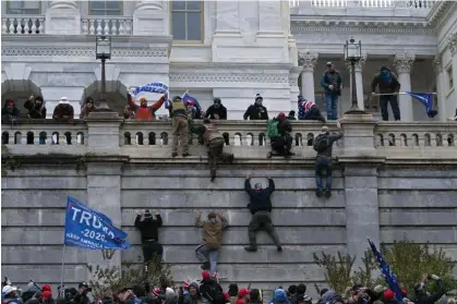  ?? Photograph: José Luis Magaña/AP ?? Supporters of President Donald Trump climb the west wall of the the US Capitol in Washington as they try to storm the building on 6 January 2021.