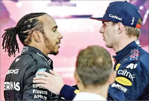  ?? AFP ?? 2021 FIA Formula One World Champion Red Bull driver Max Verstappen (right) greets second-placed Mercedes driver Lewis Hamilton after the Abu Dhabi Formula One Grand Prix at the Yas Marina Circuit on December 12.