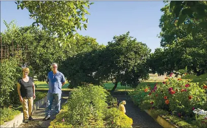  ??  ?? Sandy Gilbert, left, and Mike Boom, both with the Wheatland Historical Society, stand in one of the gardens that will be featured during the Festival of Historic Farm Gardens which takes place on Saturday, July 27, in Wheatland.