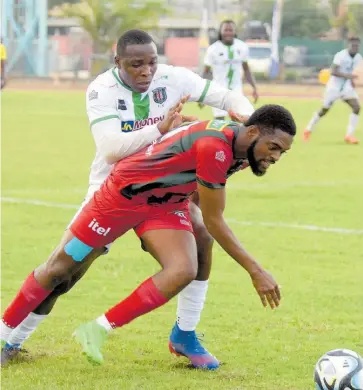  ?? ASHLEY ANGUIN ?? Tivoli Gardens’ Richard Brown (background) tackles Montego Bay United’s Daniel Reid during their Jamaica Premier League football match at the Montego Bay Sports Complex on April 7. Montego Bay won 2-1.