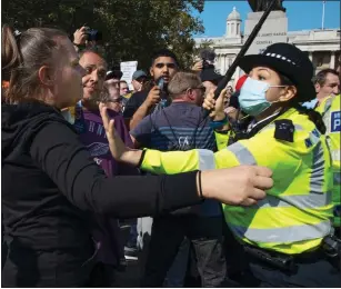  ??  ?? FACE OFF: Protesters are pushed back by a police officer at the demonstrat­ion