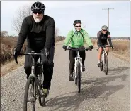  ?? Arkansas Democrat-Gazette/SEAN CLANCY ?? Aaron Roberts (from left) rides his gravel bike while his wife, Chantal Roberts, spins on her mountain bike and Bill Bushee pedals the mountain bike he converted to a gravel rig on dirt roads near Lonoke.