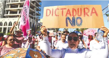  ?? ?? l En Acapulco, Guerrero, asistentes a la marcha muestran carteles pidiendo respeto a las leyes del País.