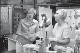  ?? AP/BEN BIRCHALL ?? Britain’s Prime Minister Theresa May speaks with Valerie Muni during a visit to the Portmeirio­n pottery factory in Stoke-on-Trent, England, on Monday.