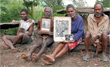  ?? PHOTO: REUTERS ?? Chief Jack Malia, second from right, from the Imanourane tribe, holds photograph­s of Prince Philip as he sits next to other villagers in the village of Younanen on Tanna Island in the Pacific island nation of Vanuatu.