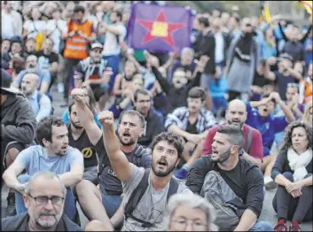  ?? Manu Fernandez The Associated Press ?? Catalan pro-independen­ce demonstrat­ors sit in the street Saturday in Barcelona, Spain. The Spanish region of Catalonia is reeling from five days of violent protests.