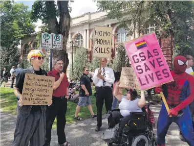  ?? THE CANADIAN PRESS/FILES ?? Protesters gathered outside a courthouse in Medicine Hat last June as a court challenge was launched against an Alberta law barring schools from telling parents if their children join a gay-straight alliance.