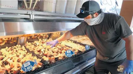  ??  ?? ABOVE: Jason Zipoli, a wholesale manager for Billy’s Stone Crab in Hollywood, sorts the stone crab display at the establishm­ent. Stone crab season will end May 1.