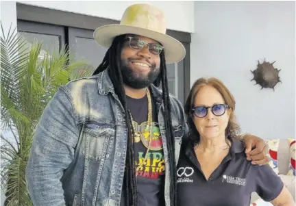  ?? ?? Grammy Award-winning reggae singer Gramps Morgan shares a momenrt with Alexandra Thomsonghi­says, group PR director, Couples Resorts.