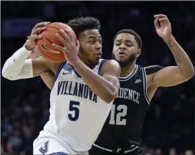  ?? LAURENCE KESTERSON - THE ASSOCIATED PRESS ?? Villanova guard Justin Moore (5) moves past Providence guard Luwane Pipkins (12) during the first half of an NCAA college basketball game, Saturday, Feb. 29, 2020, in Philadelph­ia, Pa.