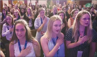  ?? ILANA PANICH-LINSMAN / THE NEW YORK TIMES ?? Women sing the national anthem to begin the second day of the Young Women’s Leadership Summit, a conference organized by Turning Point USA and sponsored by the NRA, in Dallas. An estimated 1,000 young women took part in sessions like “How Political...