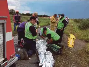  ??  ?? Paramedics attending to a victim.