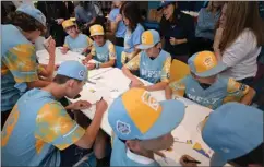  ?? ?? The team puts together welcome kits and writes notes of encouragem­ent for Ronald McDonald House families at DirecTV headquarte­rs Monday.