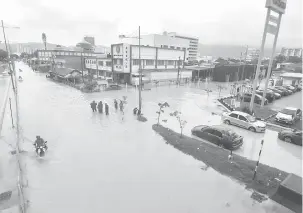  ?? — Gambar Bernama ?? REDAH: Orang ramai mengharung­i banjir kilat berikutan hujan lebat sejak tengah hari kelmarin di Jalan Sungai Pinang, Jelutong semalam.