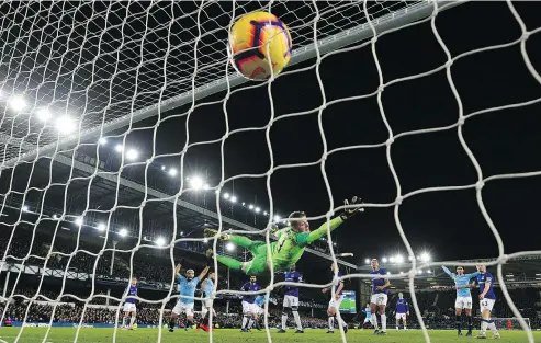  ?? —AP ?? Everton goalkeeper Jordan Pickford dives in vain as Manchester City’s Aymeric Laporte scores during an English Premier League soccer match at Goodison Park in Liverpool on Wednesday.