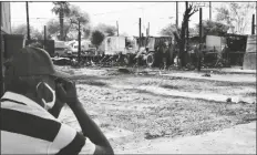  ?? PHOTO BY CESAR NEYOY/BAJO EL SOL ?? A MAN WHO LOST HIS MOBILE HOME to a fire on April 19 in Yuma watches the cleanup efforts.