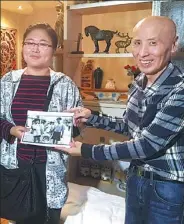  ?? PROVIDED TO CHINA DAILY ?? Wang Feng gives Sun Baiyi the original photo of Sun and her parents 20 years ago.