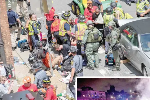  ??  ?? People receive first-aid after a car ramed into a crowd of protesters in Charlottes­ville. — AFP photo