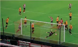  ??  ?? Sheffield United’s John Egan (hidden) gets up to head the winning goal against Wolves at Bramall Lane on Wednesday evening. Photograph: Tom Jenkins/NMC Pool/The Guardian