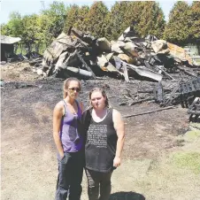  ?? ELLWOOD SHREVE ?? Lauren Edwards, left, founder of Charlotte’s Freedom Farm, and Christine Rettig, a staffer who rescued 35 animals, stand in front of a barn destroyed by a fire at the facility near Chatham on Wednesday.