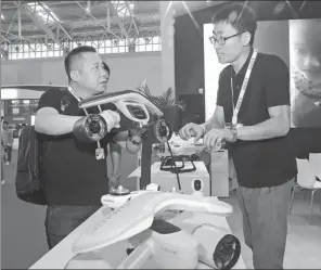  ?? JIA CHENGLONG / FOR CHINA DAILY ?? An employee of Tianjin Sublue Ocean Science & Technology Co addresses a visitor’s queries about an underwater robot at a high-tech exhibition in Tianjin.