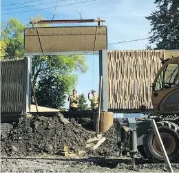  ??  ?? Workers install a sound barrier along Thorncrest Avenue near the Pierre Trudeau Internatio­nal Airport in Dorval. It runs 850 metres in length.