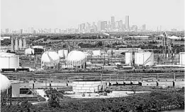  ?? DAVID J. PHILLIP/AP ?? Storage tanks are seen with downtown Houston in the background.