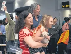  ??  ?? Que Langdon hangs on to her teddy bear as she arrives at Auckland Airport with her mother, Ariane Wyler.