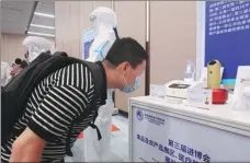  ?? WANG XIANG / XINHUA ?? A visitor looks at medical devices on display during a warm-up exhibition of the third CIIE in Shanghai.