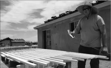  ?? Buy this photo at YumaSun.com PHOTO BY CESAR NEYOY/BAJO EL SOL ?? LEARNING THE CONSTRUCTI­ON trades is as much about practice as theory. Fernando Sosa applies finishing touches for the door frames for a home as an intern with Housing American Corp., a Somerton-based non-profit organizati­on that administer­s a selfhelp housing program for clients.