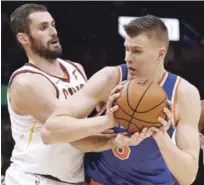  ?? AP ?? Kristaps Porzingis, de los Knicks, trata de avanzar hacia el canasto ante la defensa de Kevin Love, de los Cavaliers, en acción de ayer en la NBA.