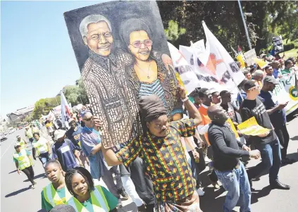  ?? Picture: Michel Bega ?? MARCH. A man carries a painting of Nelson Mandela and Graca Machel during an anti-xenophobia march organised by the African Diaspora Forum in Johannesbu­rg yesterday.