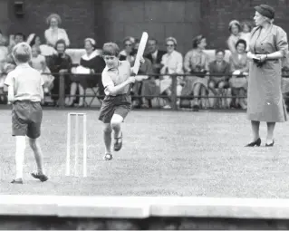  ??  ?? FAMILY VALUES Prince Charles plays cricket, one of his father’s favourite sports, at the Hill House School Field Day in Chelsea in 1957. Philip’s first birthday present to his son was a cricket bat. Right; the Queen and Duke of Edinburgh take Andrew to see the dogs at Balmoral in 1972