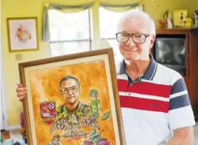  ?? STAFF PHOTO BY ERIN O. SMITH ?? At his house in Rossville, Ga., Bud Connally holds a piece of art someone made for him. Connally is a 28-year career veteran who served in the U.S. Army. He served two tours of duty in Vietnam, two in Germany and one in Operation Desert Storm.