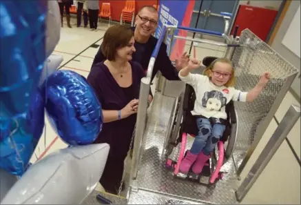  ?? DAVID BEBEE, RECORD STAFF ?? Joined by her parents Zoran and Marina, Glencairn Public School student Bella Vujicic sits on the new portable, non-motorized wheelchair lift that will help improve her schooling. The lift was made possible by the barrier buster project, part of the...