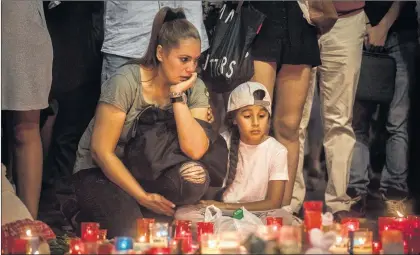  ?? AP PHOTO ?? A woman and her child observe a memorial tribute to the victims of the terrorist attack on the historic street of Las Ramblas one day after the terrorist attack, in Barcelona, Spain, on Friday.