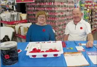  ?? NEWS PHOTO GILLIAN SLADE ?? Gerri and Allan Renz volunteer at one of the poppy campaign tables that opened across the city on Friday. It is a tradition they have been keeping for several years honouring veterans ahead of Remembranc­e Day.