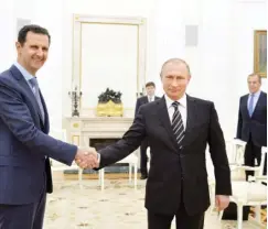  ??  ?? Russian President Vladimir Putin shakes hands with Syrian President Bashar Assad during a meeting at the Kremlin in Moscow on Tuesday. Photo REUTERS