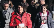  ?? JEFF MCINTOSH/THE CANADIAN PRESS ?? Marilyn Thompson, in red, sister of Gordon Klaus, leaves court with family and friends after Joshua Frank and Jason Klaus were sentenced in Red Deer on Wednesday.