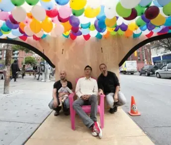  ?? KEITH BEATY/TORONTO STAR ?? Designers Marek Rudzinski (holding his daughter, Clara), Andrew Chiu and Timothy Mitanidis sit in the park they created in a parking spot on Queen St. W., in honour of Internatio­nal Park(ing) Day on Friday.