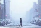  ?? MIKE DE SISTI/USA TODAY NETWORK ?? A pedestrian walks through the snow across North Jefferson Street in Milwaukee on Thursday. Milwaukee was expecting 6 to 10 inches of snow, while most of southeaste­rn Wisconsin was under a winter storm warning.