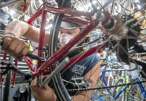  ?? Steph Chambers/Post-Gazette ?? Mechanic Wyatt Morrus works on a bike Wednesday at Kraynick’s Bike Shop in Garfield. Kraynick’s has seen an increase in business during the COVID-19 pandemic.