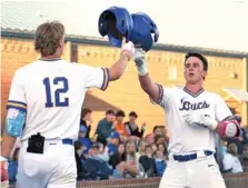  ?? STAFF PHOTO BY ROBIN RUDD ?? Boyd Buchanan’s Cooper Jones (12) touches helmets in celebratio­n with Brodie Johnston, who had just hit a solo home run for for the Buccaneers in Thursday’s game against visiting Walker Valley. Boyd Buchanan is off to a strong start in Stephen Pryor’s fith season as head coach.