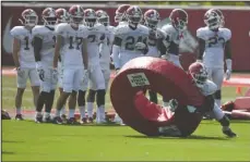  ?? NWA Democrat-Gazette/J.T. Wampler ?? HITTING THE RING: Razorbacks’ Kamren Curl hits the tackle ring Wednesday during practice while his teammates look on.