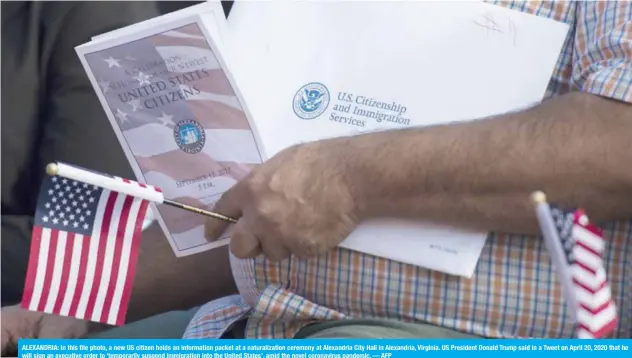  ?? — AFP ?? ALEXANDRIA: In this file photo, a new US citizen holds an informatio­n packet at a naturaliza­tion ceremony at Alexandria City Hall in Alexandria, Virginia. US President Donald Trump said in a Tweet on April 20, 2020 that he will sign an executive order to ‘temporaril­y suspend immigratio­n into the United States’, amid the novel coronaviru­s pandemic.