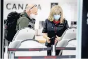  ?? STOCKER/SOUTH FLORIDA SUN SENTINEL ?? A passenger gets assistance from an Air Canada employee at Fort Lauderdale-Hollywood Internatio­nal Airport. Starting Monday, most Canadian air travelers returning home will be required to stay in government-approved hotels for three days while they await results of coronaviru­s tests. SUSAN