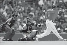  ?? MICHAEL DWYER/AP PHOTO ?? Boston Red Sox third baseman Rafael Devers, right, follows through on an RBI double in front of Baltimore Orioles catcher Chance Sisco during the sixth inning of Sunday’s game at Boston.